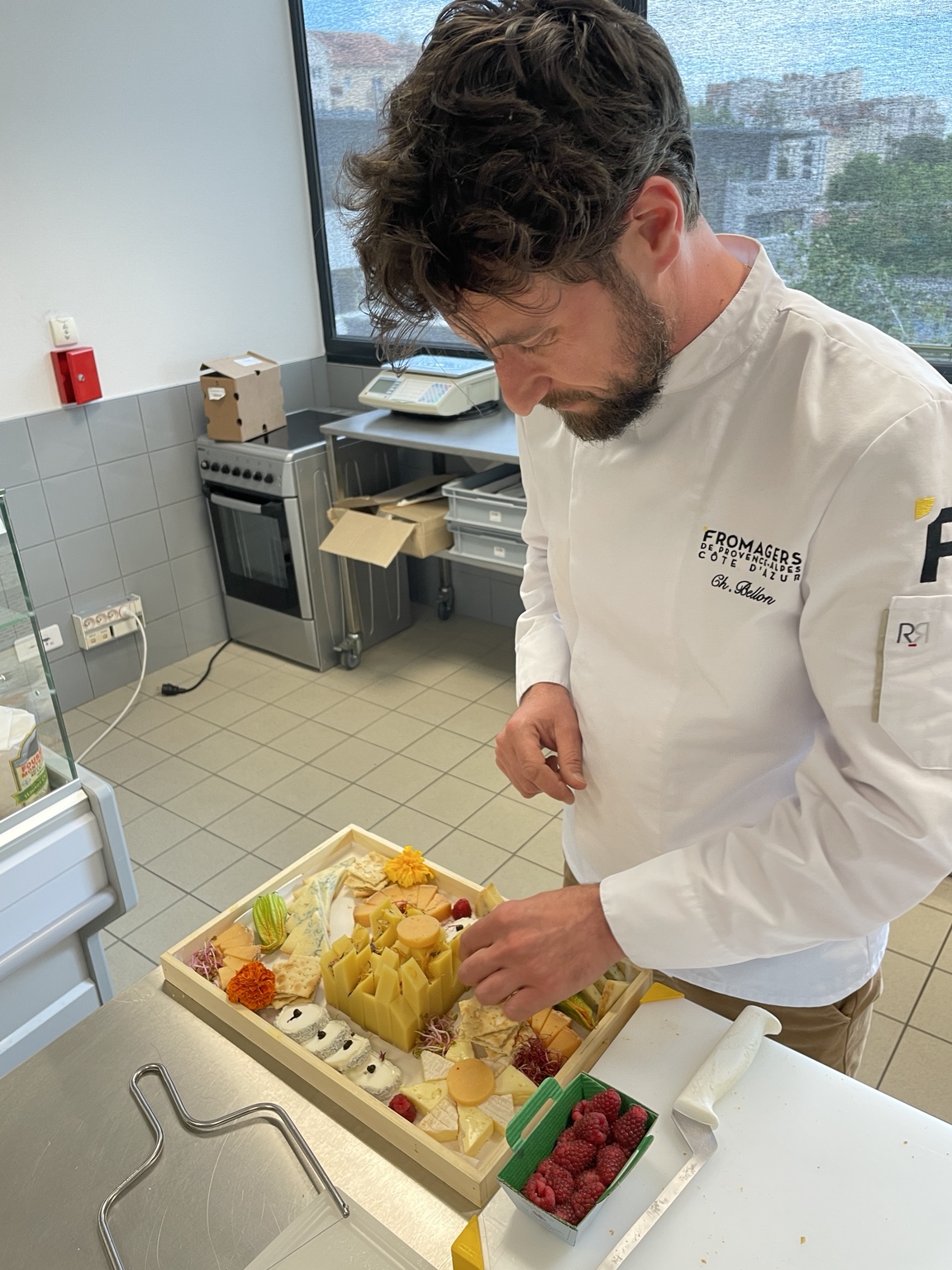 Charles-Henri Bellon dressant une sélection de fromages en tenue professionnelle